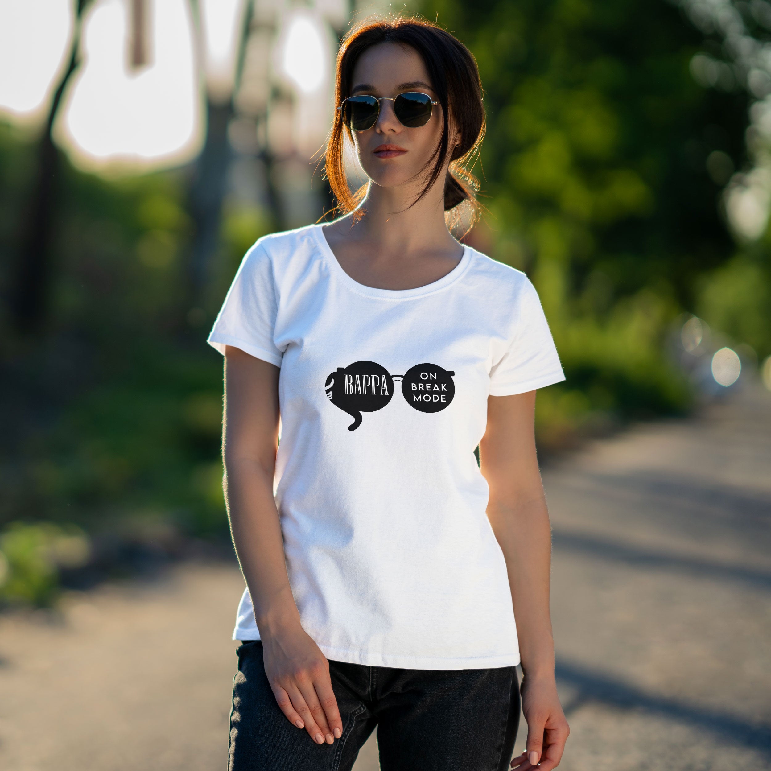 Woman wearing a white t-shirt with a graphic design in front of a colorful graffiti wall.
