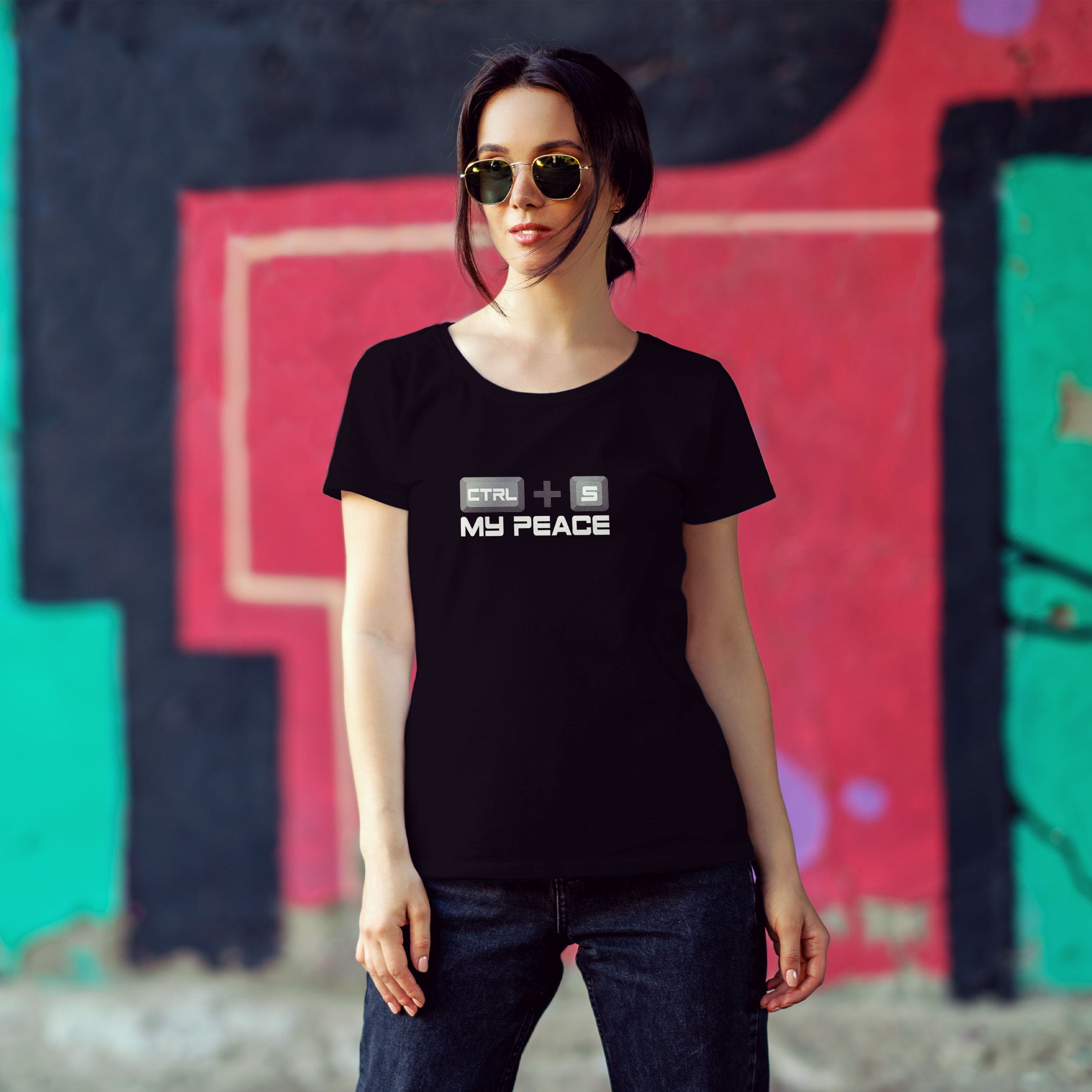 Woman wearing a black t-shirt with text in front of colorful graffiti