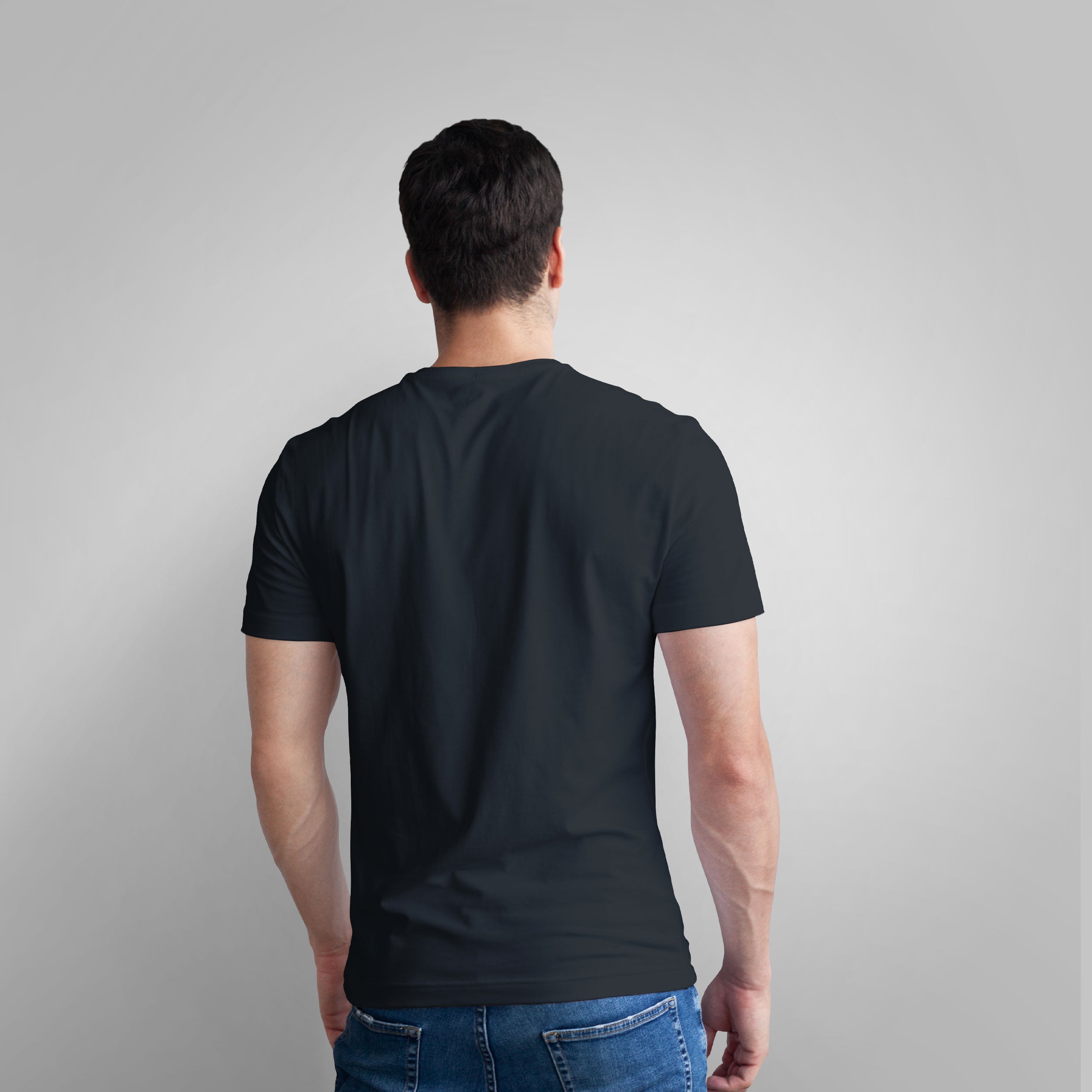 Man wearing a black t-shirt with an orange graphic design on a gray background