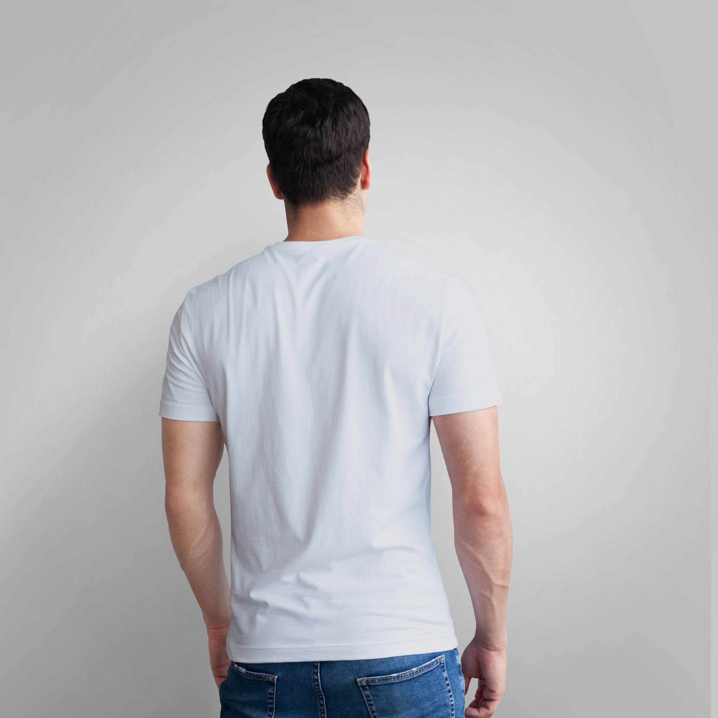 Man wearing a white t-shirt with a motivational quote on a plain background
